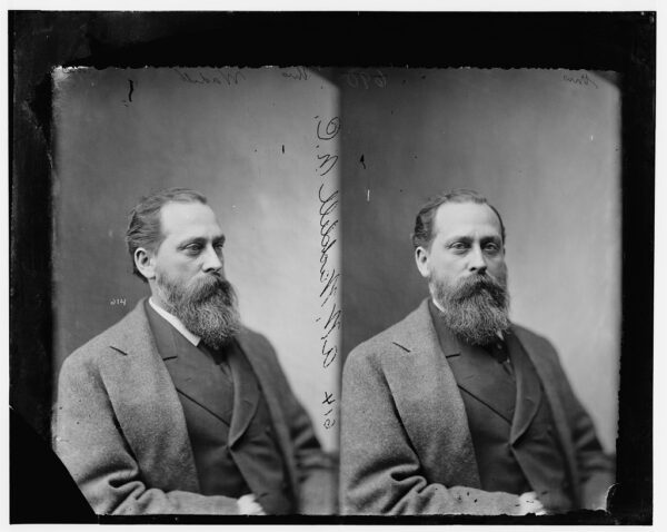 Two side-by-side portraits of an older white man with a large bushy beard and slicked back hair who is wearing a coat, vest, and tie.