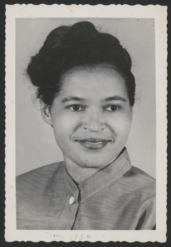 A Black young adult woman with dark hair in an updo smiles in a photograph that sppears to be for a school yearbook or similar.