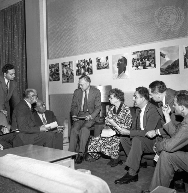 A black and white photograph of members of the Universal Declaration of Human Rights drafting committee sitting on chairs and couches in a television studio.