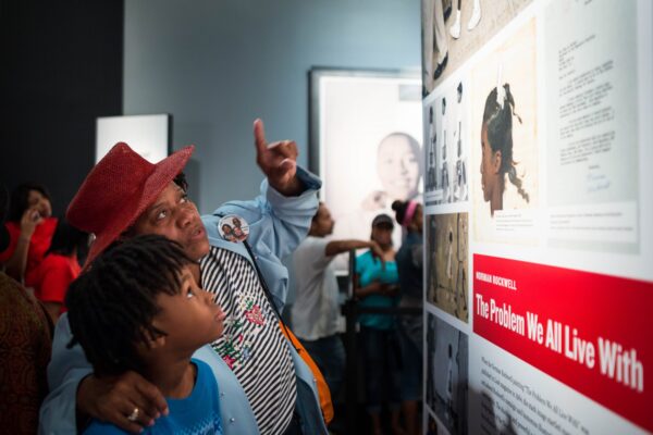 Center volunteer highlights primary resources within exhibition panels.