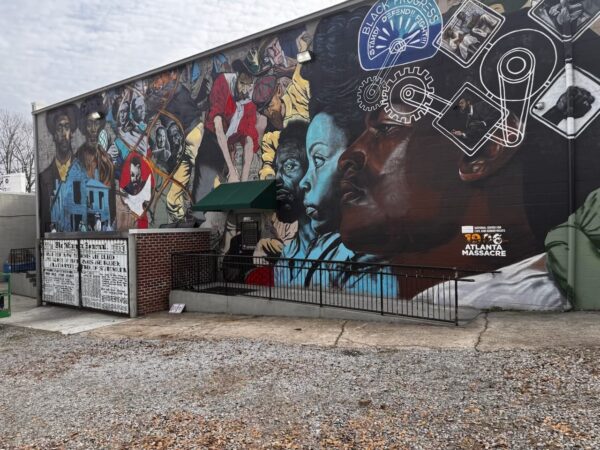 Photograph of an outdoor mural featuring images from the 1906 Atlanta Race Massacre.