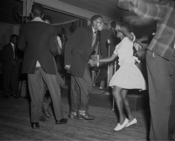 African American men and women dancing energetically at the Peacock Club on Auburn Avenue, with a live band and microphone visible in the background, Atlanta, 1943