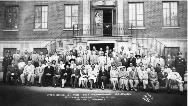 Large group of African American men and women posed on steps outside the Butler Street YMCA in Atlanta for a 1953 membership campaign, dressed in formal mid-century clothing